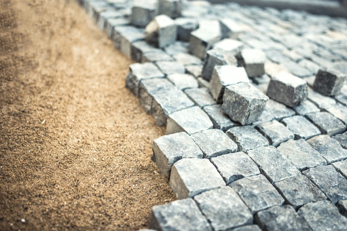 Partially completed cobblestone paving with square-cut gray stones in provided hardscape service
